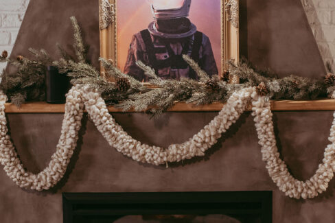 Firepace and space man art for the Christmas season at Nest:Space™ coworking, in the basement private desk room, designed by Shawna Meyer Design™, Interior Design and Project Management